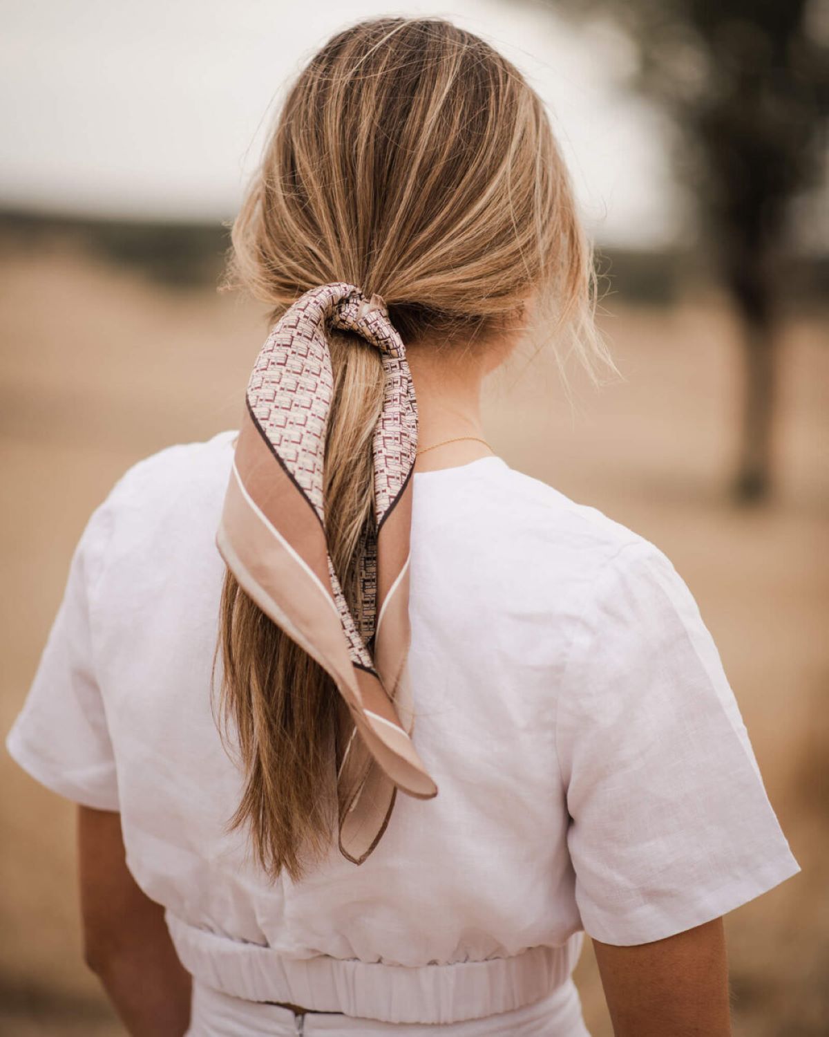 Tie your hair in a ponytail with a silk scarf